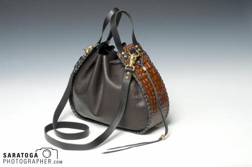 Brown leather handbag on gradated dark to light background
